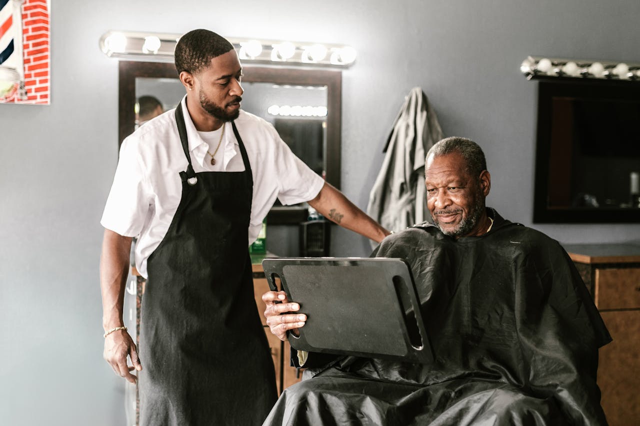 A barber and his client enjoying a moment in a modern barbershop, highlighting friendly service.